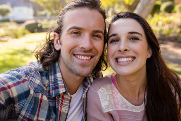 istock Young couple smiling in park 649972480