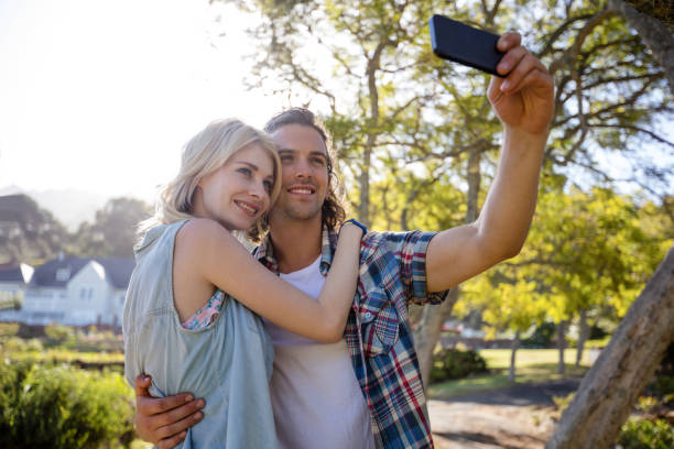 istock Couple clicking a selfie in park 649976402