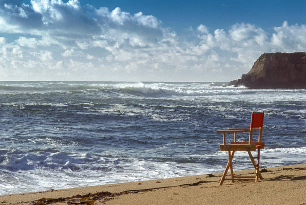 istock Chair in Sand with Ocean and Rocky Shore View 649986952