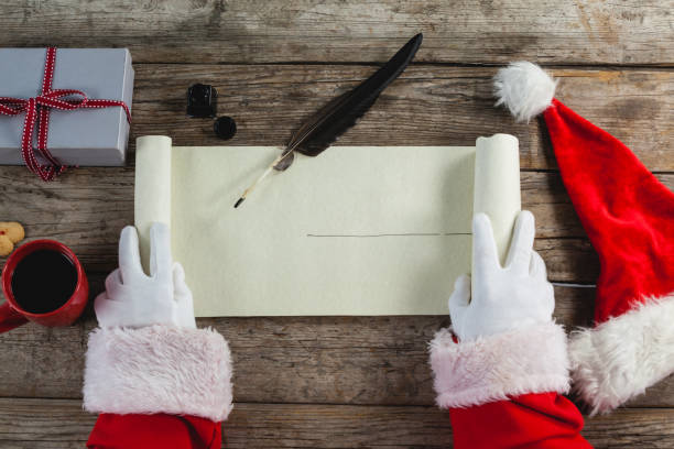 istock Close-up of santa claus opening scroll 649987090