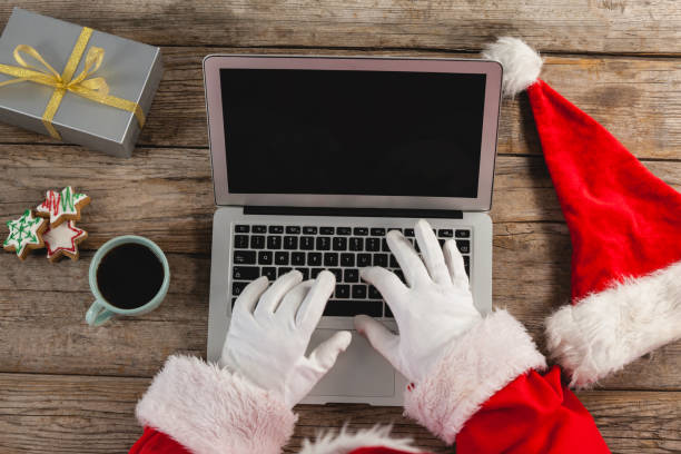 Close-up of santa claus using laptop Close-up of santa claus using laptop on table traditional sport stock pictures, royalty-free photos & images