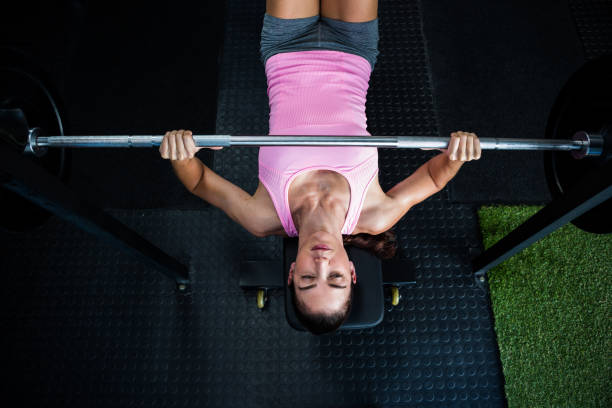 istock High angle view of athlete holding barbell while lying on bench press 649987992