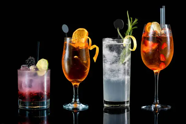 various cocktail drinks on bar counter with dark background fresh fruit decoration garnish