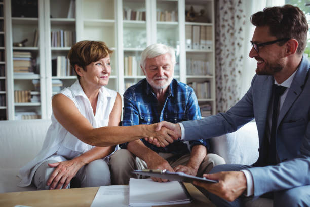 consulente finanziario che stringe la mano a una donna anziana - retirement senior adult finance couple foto e immagini stock