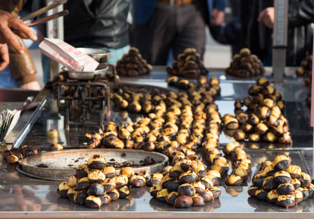 istock Organic brown chestnuts roasted over a hot fire for sale 650048360