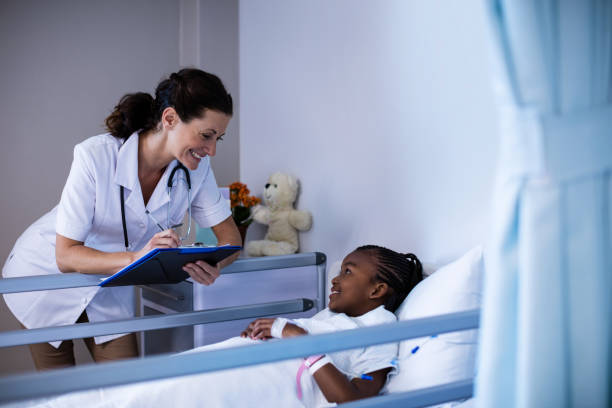 istock Female doctor writing on clipboard while interacting with patient 650063484