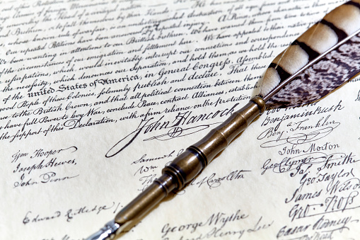 Close up of John Hancock signature on US Constitution with a quill pen