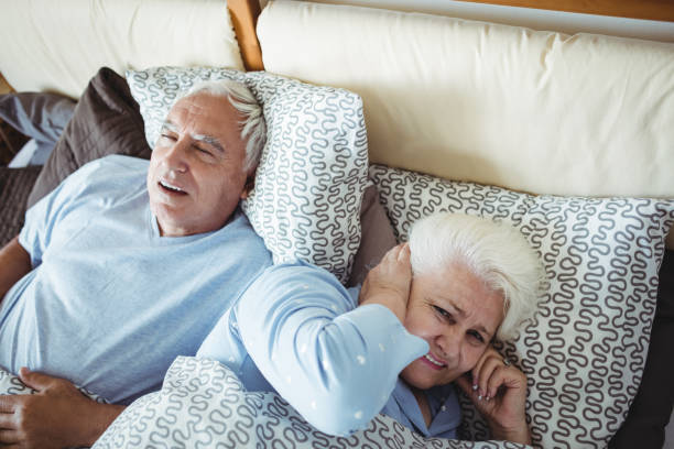 schnarchen mann und frau für ihre ohren während des schlafens auf bett - couple love snoring sleeping stock-fotos und bilder