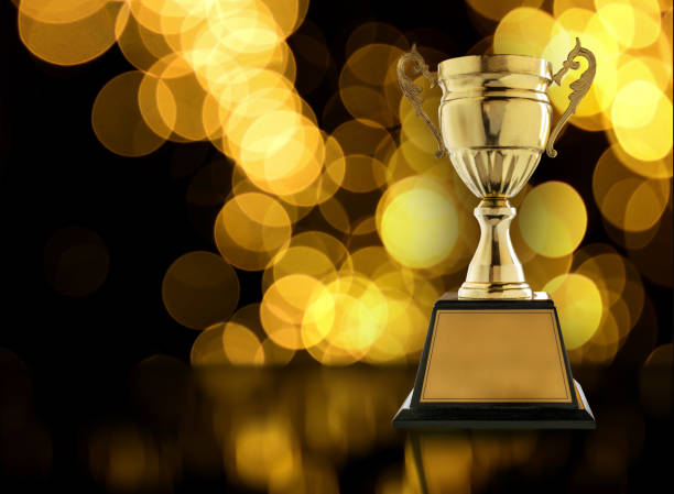 istock Trophies placed on a wooden table with gold light bokeh background copy space ready for your design. 650110984