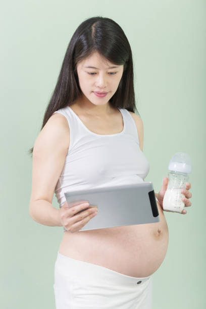 istock young pretty pregnant woman with bottle 650111004