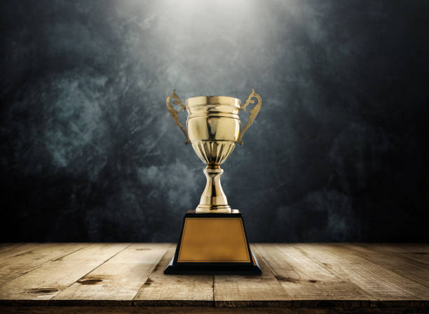 istock champion golden trophy placed on wooden table with dark background copy space ready for your design. 650111136