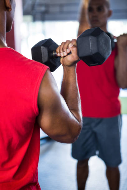istock Reflection of man exercising with dumbbells 650113936