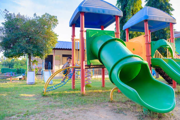 istock Little Asian kid playing slide at the playground 650121192