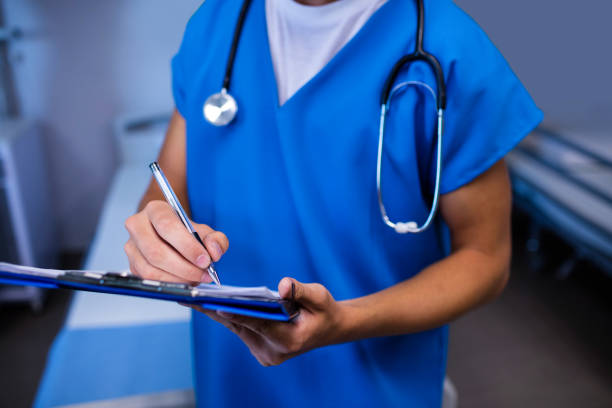 istock Mid section of nurse writing on clipboard in ward 650125868