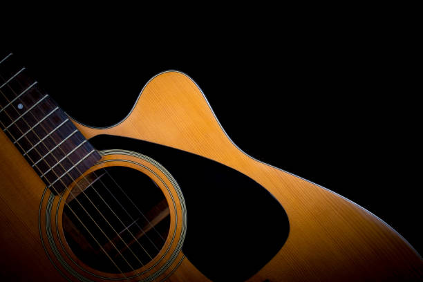istock acoustic guitar detail on black background 650134324