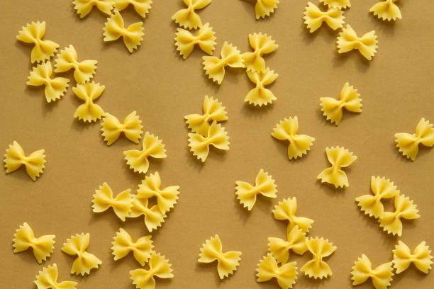 istock Pasta bow and spiral shape on brown background 650142030