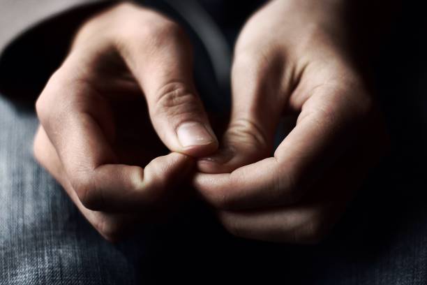 Quiet Anxiety A pair of hands placed anxiously in a lap with natural colors and lighting. edgy man stock pictures, royalty-free photos & images