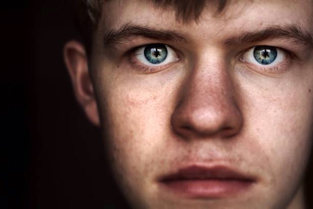 Young Male with Neutral Gaze Close-up portrait of single young male with neutral gaze into camera. mesmerised stock pictures, royalty-free photos & images