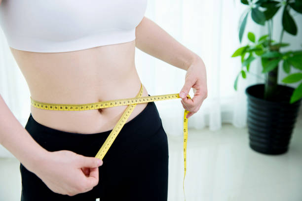 istock Young woman measuring her waist 650158520