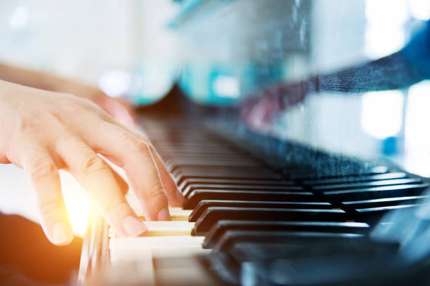 Playing a piano Man hand playing a piano. pianist stock pictures, royalty-free photos & images