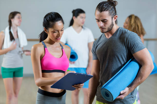 Female trainer helping man on her work out routines