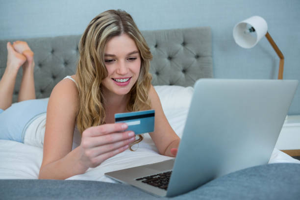 istock Woman doing online shopping with her laptop on bed 650174010