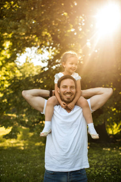 istock Happy father carrying his small daughter on shoulders in nature. 650174148
