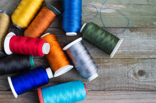 istock Multi-colored thread rolls pile of colorful spools of thread on wood 650174292