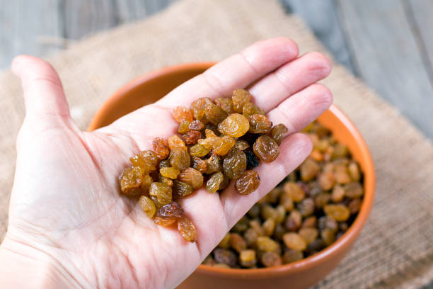 istock Dried raisin in hand over wooden background 650182652