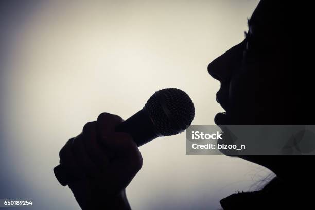 Photo libre de droit de Femme Et Dun Microphone banque d'images et plus d'images libres de droit de Chanteur - Chanteur, Couleur noire, Silhouette - Contre-jour