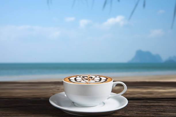 istock Coffee on wood table in the beach. 650189454