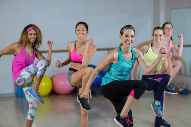 Group of women performing aerobics in fitness studio