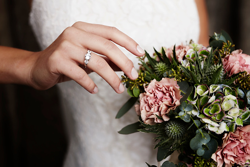 Wedding ring and blooming flowers, close up