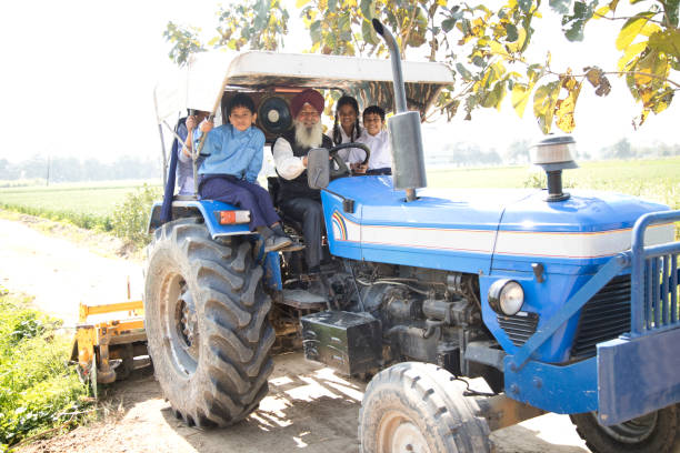 istock Old man with grand children riding tractor 650206178