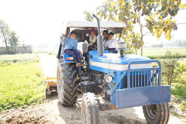 istock Old man with grand children riding tractor 650206884