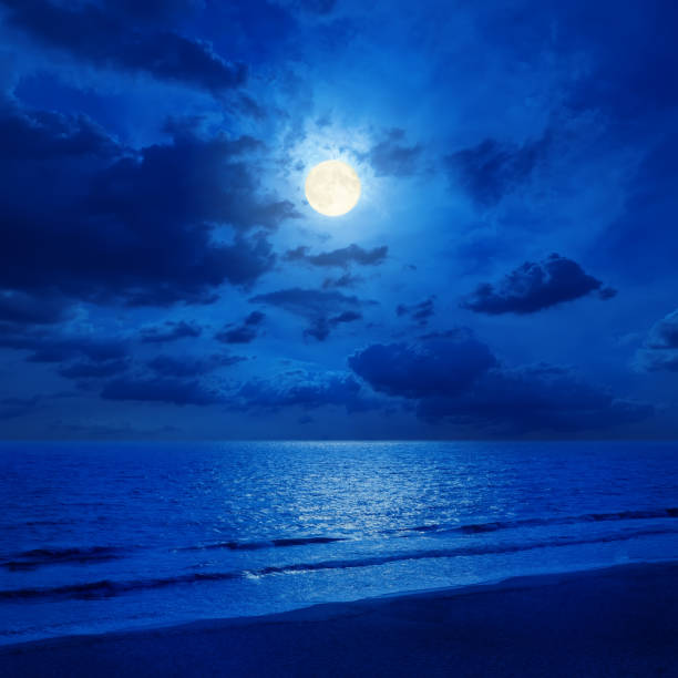 istock full moon in cloudy sky and sea with reflections 650218782