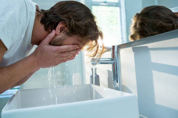 istock Man washing his face with water in bathroom 650222316