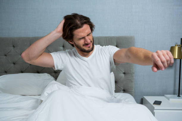 istock Man waking up in bed and stretching her arms 650222898