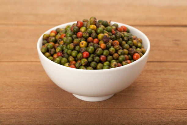 frisches grün und orange pfefferkörner - directly above macro pepper black peppercorn stock-fotos und bilder