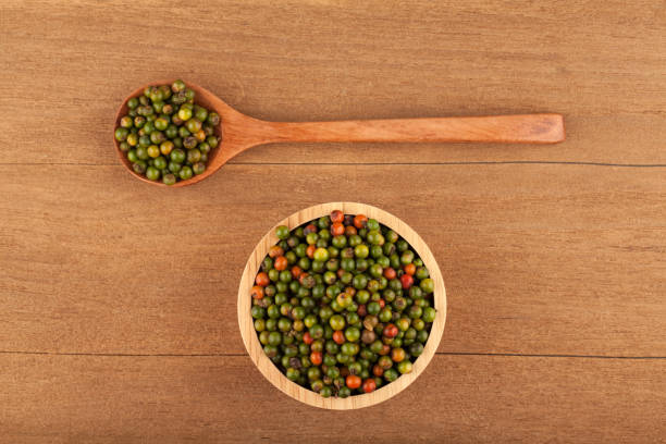 frisches grün und orange pfefferkörner - directly above macro pepper black peppercorn stock-fotos und bilder