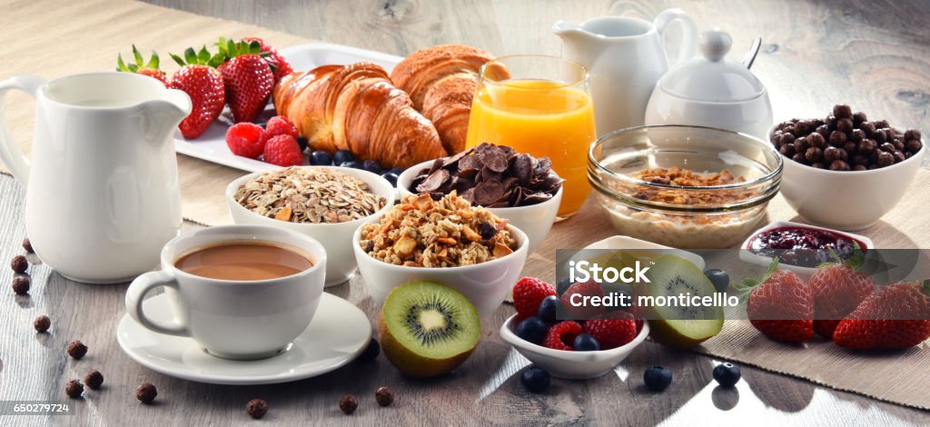 Breakfast served with coffee, juice, croissants and fruits Breakfast served with coffee, orange juice, croissants, cereals and fruits. Balanced diet. Breakfast Stock Photo