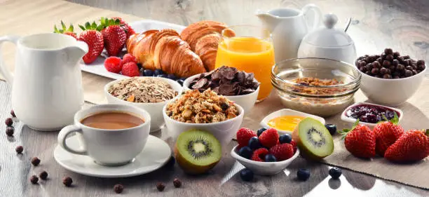 Photo of Breakfast served with coffee, juice, croissants and fruits