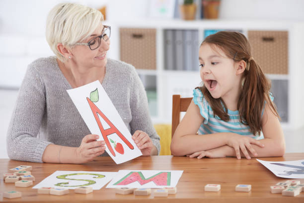 istock Girl spelling letters with therapist 650281728