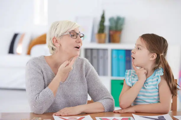 Stuttering girl and speech therapist doing exercises