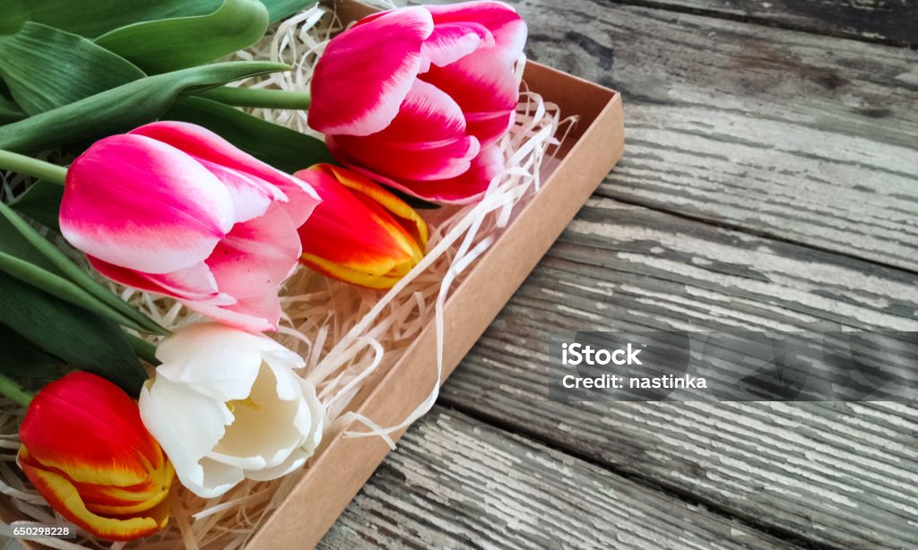 Tulips flowers bunch on an old wooden table Architectural Column Stock Photo