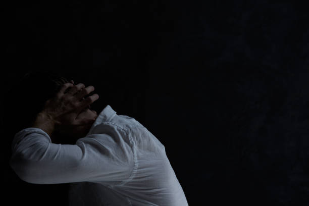 istock Despair man in dark room 650326686