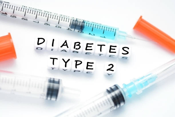 Type 2 diabetes text spelled with plastic letter beads placed next to an insulin syringe stock photo
