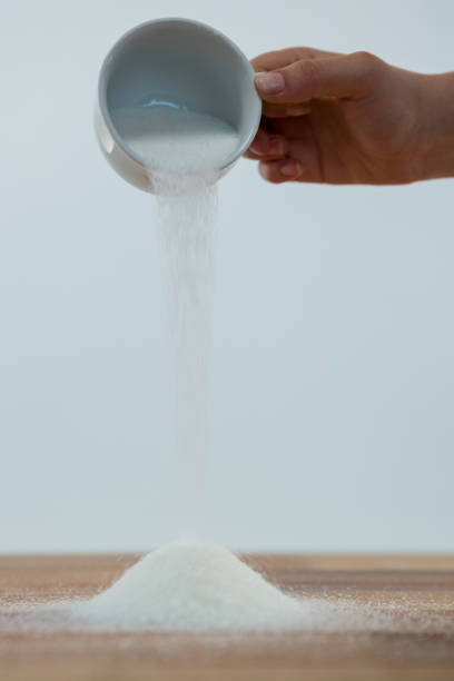 istock Woman hand pouring sugar on a wooden table 650344988