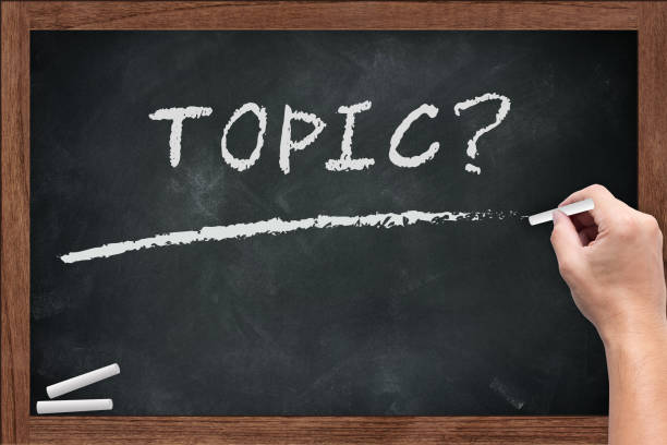 istock Topic word chalkboard with hand hold chalk on wooden board dirty with chalk stain empty space for text 650379058