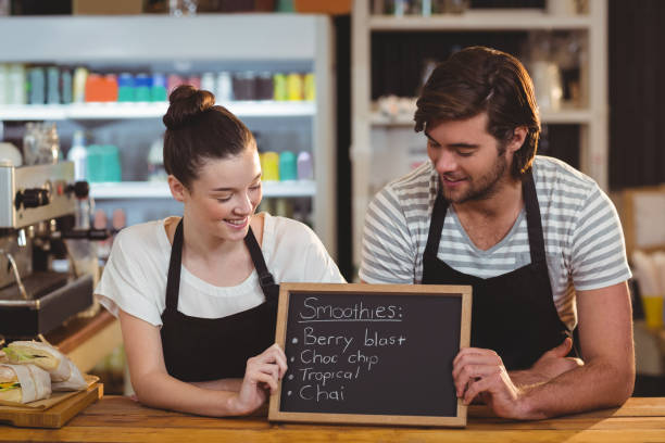 istock Waiter and waitress holding chalkboard at counter 650382544
